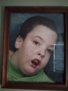 A framed childhood portrait of Jason wearing a green shirt